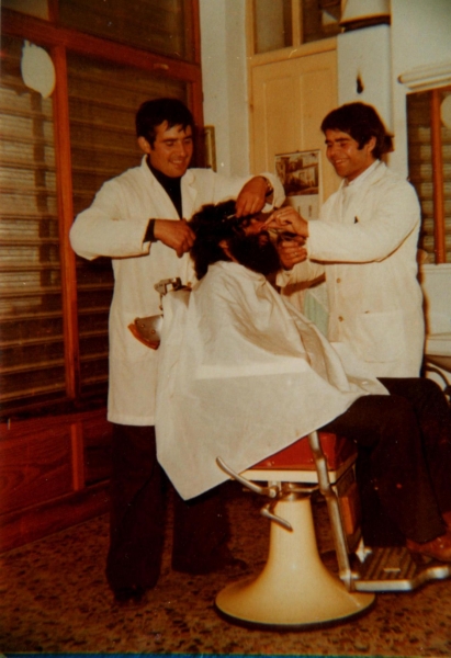 Bartolomeo Ladu (a destra) con Virginio Frau mentre taglia i capelli a Taniele